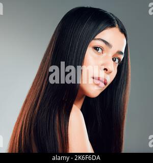 Schönes Haar ist ein modisches Statement. Studioaufnahme einer schönen jungen Frau mit langen braunen Haaren. Stockfoto