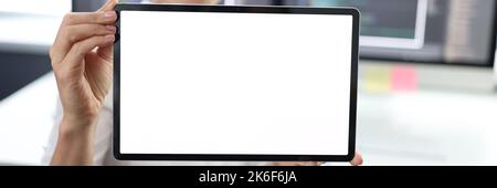 Frau hält Tablet mit weißem Bildschirm. Bei der Arbeit Stockfoto
