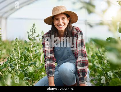 Ich liebe es, die ganze Sorgfalt in meinen blühenden Garten zu stecken. Porträt einer jungen Frau, die auf einem Bauernhof arbeitet. Stockfoto