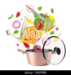 Fliegendes frisches Gemüse mit Utensilien und Saucepot auf weißem Hintergrund Stockfoto