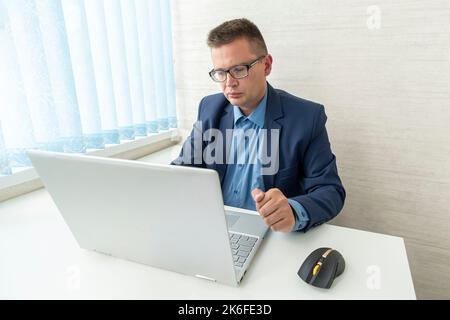 Porträt eines seriös eleganten, gut aussehenden Geschäftsmannes und professionellen Geschäftsführerin. Hübscher reifer kaukasischer Mann in Anzug in der Nähe des Schreibtisches in Mo Stockfoto
