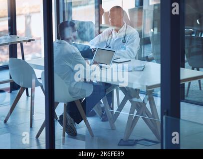 Ärzte, Männer und Laptop bei Krankenhausbesprechung zur OP-Planung, Versicherungsanwendung oder medizinischen Labordatenanalyse. Mitarbeiter im Gesundheitswesen, Teamarbeit oder Stockfoto