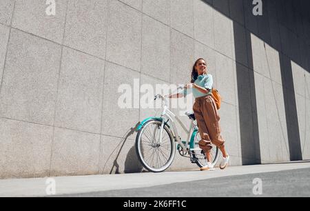 Fahrrad, urban und schwarze Frau Radfahren in der Stadt Norwegen für einen nachhaltigen Lebensstil. Glücklich, jung und lächeln afrikanisches Mädchen mit einem Fahrrad, das Öko ist Stockfoto