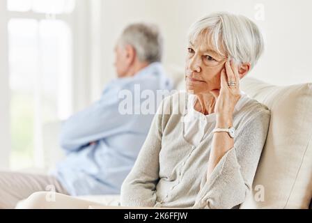 Wähle Ruhe. Ein reifes Paar, das nach einer Meinungsverschiedenheit auf dem Sofa zu Hause genervt aussieht. Stockfoto