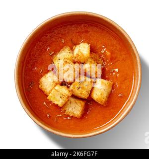 Dicke, kalte Gazpacho-Suppe mit Croutons in einer Pappschale, die auf Weiß gelötet ist Stockfoto