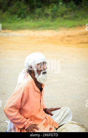 Bettler sitzt vor einem Tempel in Indien Stockfoto