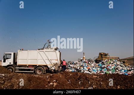 Mülldeponie. Arbeiter mit Lastwagen und Planierraupen arbeiten auf Mülldeponien. Stockfoto