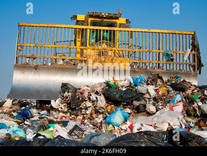 Mülldeponie. Arbeiter mit Lastwagen und Planierraupen arbeiten auf Mülldeponien. Stockfoto