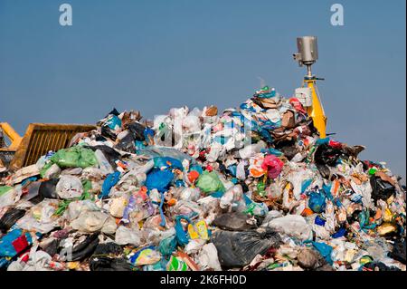 Mülldeponie. Arbeiter mit Lastwagen und Planierraupen arbeiten auf Mülldeponien. Stockfoto