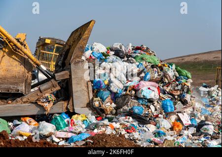 Mülldeponie. Arbeiter mit Lastwagen und Planierraupen arbeiten auf Mülldeponien. Stockfoto