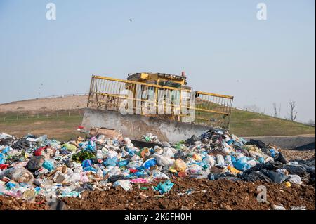 Mülldeponie. Arbeiter mit Lastwagen und Planierraupen arbeiten auf Mülldeponien. Stockfoto