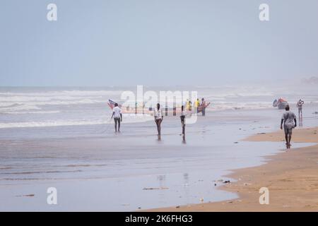 Accra, Ghana - 06. April 2022: Einheimische Afrikaner haben Spaß an der sandigen Küste des Ghana Ocean Stockfoto