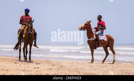 Accra, Ghana - 06. April 2022: Einheimische Afrikaner haben Spaß an der sandigen Küste des Ghana Ocean Stockfoto