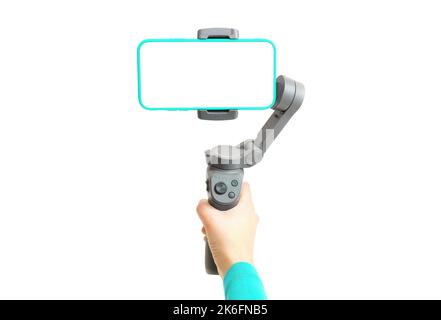 Die Hand hält einen 3-Achsen-Gimbal-Stabilisator mit einem Smartphone auf weißem Hintergrund isoliert. Stockfoto