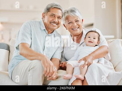 Sicher in den Armen von Nana. Großeltern verbinden sich zu Hause mit ihrem Enkelkind auf einem Sofa. Stockfoto