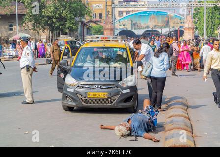 Mumbai, Maharashtra, Südindien, 31.. Dezember 2019: Ein Taxi und ein betrunkener Mann liegen auf der Straße. Stockfoto