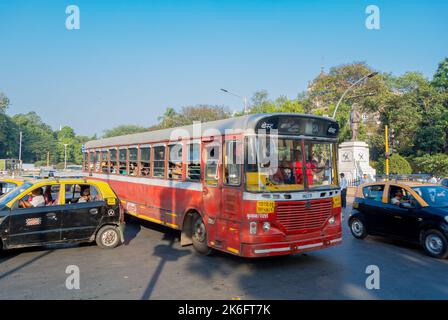 Mumbai, Maharashtra, Südindien, 31.. Dezember 2019: Orangefarbener öffentlicher Buse und Taxis auf der Straße Stockfoto