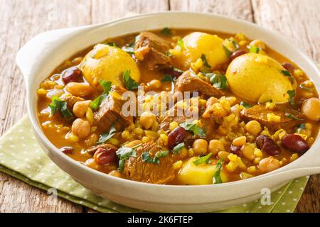 Nahaufnahme des traditionellen jüdischen Cholent Hamin Hauptgerichtes für das Schabbat-Gericht, langsam gekochtes Rindfleisch mit Kartoffeln, Bohnen und braunen Eiern in der Pfanne Stockfoto