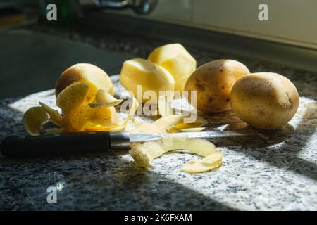 Geschälte Kartoffeln auf einer Küchenarbeitsplatte Stockfoto