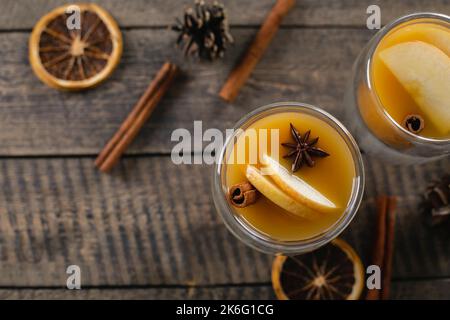 Zwei Gläser mit Apfel-cidr auf Holztischhintergrund. Warme Wintergetränke. Draufsicht, Kopierbereich. Stockfoto