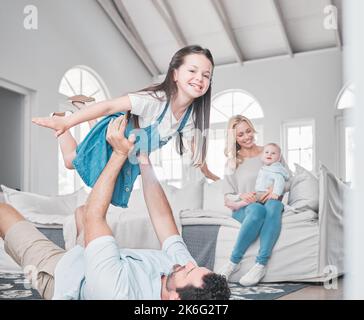 Ich liebe meine perfekte Familie. Eine junge Familie, die sich auf dem Boden des Wohnzimmers amüsieren kann. Stockfoto