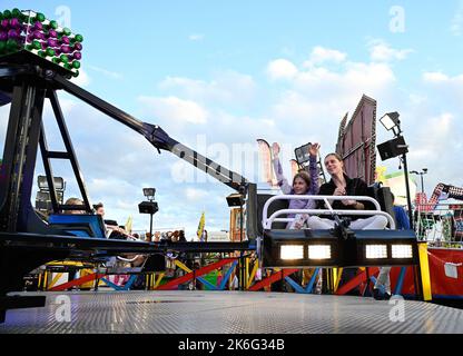 7.. Oktober 2022, Tewkesbury, Gloucestershire, England. Tewkesbury Mop Fair. Eine Mutter und Tochter genießen „The Sizzler“, eine Fahrt auf der Tewkesbury Mop Fair. Die Tewkesbury Mop Fair findet seit 1199 statt und ist eine der größten und bekanntesten traditionellen Straßenmessen des Landes. Stockfoto