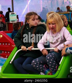 7.. Oktober 2022, Tewkesbury, Gloucestershire, England. Tewkesbury Mop Fair. Mädchen reagieren, als ihre Fahrt zu Ende geht Die Tewkesbury Mop Fair findet seit 1199 statt und ist eine der größten und bekanntesten traditionellen Straßenmessen des Landes. Stockfoto
