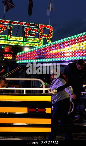 7.. Oktober 2022, Tewkesbury, Gloucestershire, England. Tewkesbury Mop Fair. Menschen, die auf der Tewkesbury Mop Fair von den Fahrgeschäften aussteigen. Die Tewkesbury Mop Fair findet seit 1199 statt und ist eine der größten und bekanntesten traditionellen Straßenmessen des Landes. Stockfoto