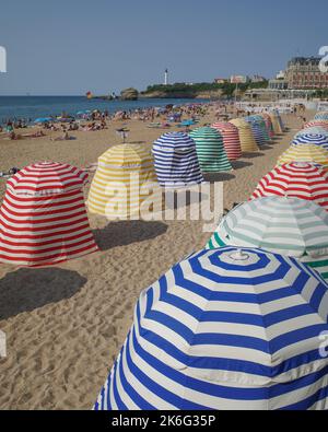 Biarritz, Frankreich - 22. Juli 2022: Farbenfrohe Sonnenschutzhütten am Grand Plage Strand in Biarritz Stockfoto