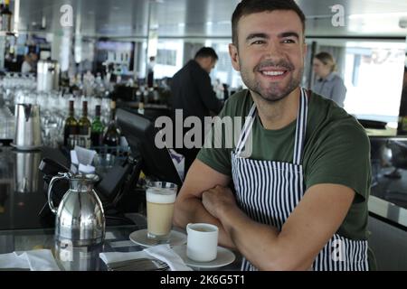 Barista serviert eine Kaffeetasse Stockfoto