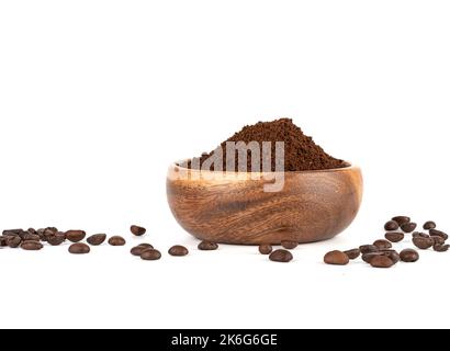 Gemahlener Kaffee in einer Holzschüssel und Kaffeebohnen auf weißem Hintergrund. Speicherplatz kopieren. Stockfoto