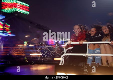7.. Oktober 2022, Tewkesbury, Gloucestershire, England. Tewkesbury Mop Fair. Freunde auf einer gemeinsamen Fahrt. Allgemeiner Blick auf die Tewkesbury Mop Fair. Die Tewkesbury Mop Fair findet seit 1199 statt und ist eine der größten und bekanntesten traditionellen Straßenmessen des Landes. Stockfoto