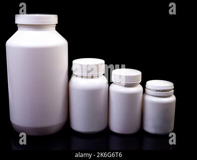 Draufsicht Mockup-Flasche für Pillen und Vitamine auf schwarzem Hintergrund, natürliche Bio-Ergänzung Medizinische Pillen in weißem Glas auf einem isolierten schwarzen Rücken Stockfoto