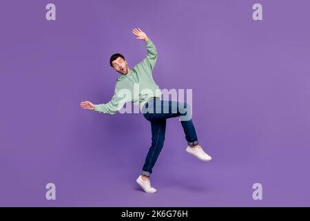 In voller Größe Profil Foto von jungen aufgeregt lustigen Mann tragen stilvolle Outfit überrascht Hände nach oben gehen leise kindisch isoliert auf pastellviolette Farbe Stockfoto