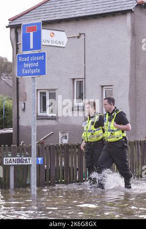 Kendal, Cumbria - Dezember 6. 2015 - Polizeibeamte aus Cumbria laufen am 6.. Dezember 2015 durch das Hochwasser von Sandgate in Kendal, Cumbria, um den von den Überschwemmungen des Sturms Desmond betroffenen Bewohnern zu helfen. PIC Credit: Scott CM/Alamy Live News Stockfoto