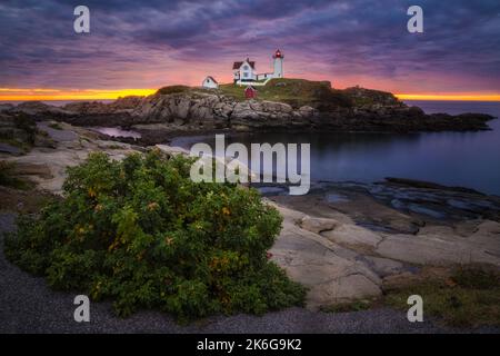 Nubble Light Sunrise ME - Blick auf einen wunderschönen, dramatischen Himmel mit der aufgehenden Sonne hinter dem legendären Nubble Lighthouse am Cape Neddick in Y Stockfoto