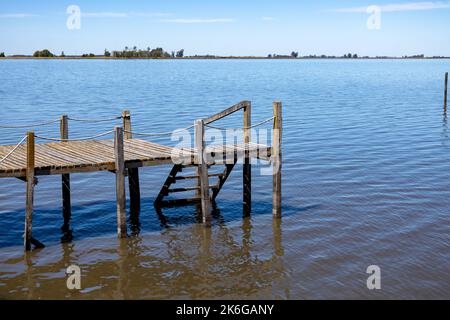 Kleiner hölzerner Pier an einer Lagune. Dock für Wasseraktivitäten. Stockfoto