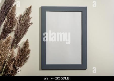 Rahmen Mockup und getrocknete natürliche Pampas Gras. Inneneinrichtung. Mockup leeren Diplomrahmen auf weißem Wandhintergrund. Rahmen mit blanko Weiß Stockfoto