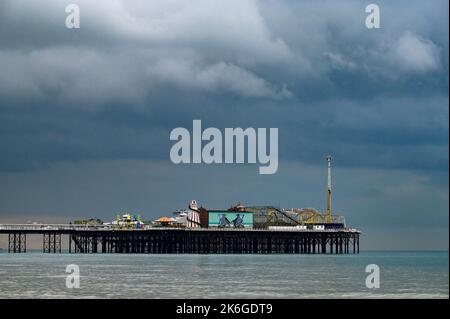 Brighton UK 14. October 2022 - Dunkle Wolken über dem Brighton Palace Pier während eines düsteren Tages an der Südküste. : Credit Simon Dack / Alamy Live News Stockfoto