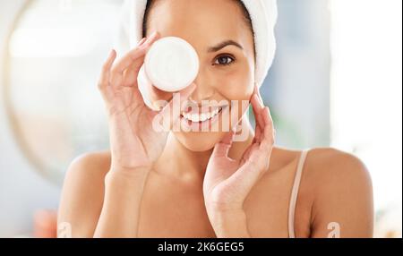 Die beste Augencreme. Eine junge Frau, die zu Hause Creme auf ihr Gesicht aufgetragen hat. Stockfoto