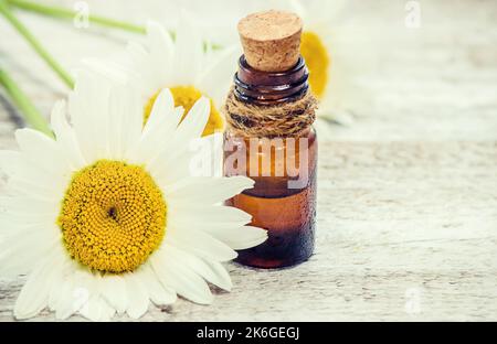 Ätherisches Öl der Kamille in einer kleinen Flasche. Selektiver Fokus. Natur. Stockfoto