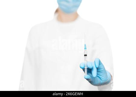 Arzt mit einer Spritze in blauen Handschuhen Stockfoto