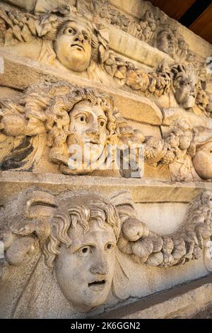 Friesen auf dem Tiberius-Portikus, in dem verschiedene Götter, Göttinnen und Porträtköpfe in Aphrodisias, Aydin, Türkei, abgebildet sind. Stockfoto