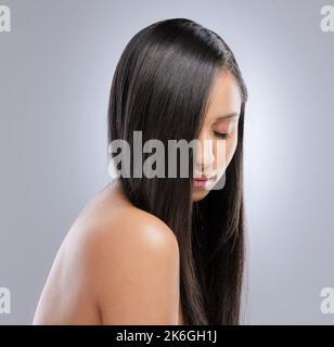 Dunkel und schön. Studioaufnahme eines schönen Jungen mit gesunden braunen Haaren. Stockfoto