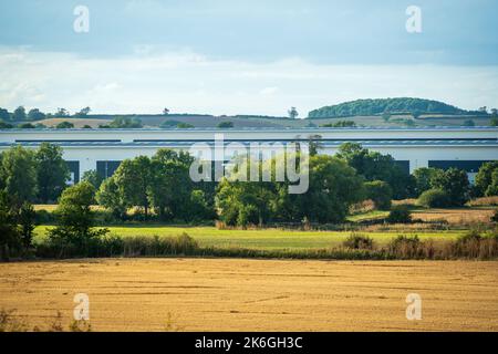 Neu erbautes Distributionslager mit landwirtschaftlichen Feldern im Vordergrund in england Stockfoto