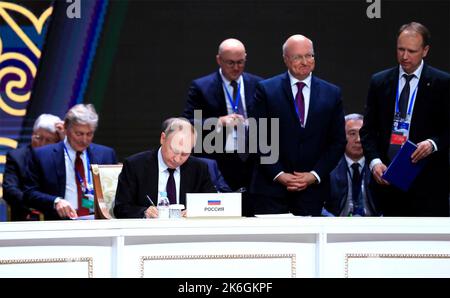 Astana, Kasachstan. 14. Oktober 2022. Der russische Präsident Wladimir Putin unterzeichnet die gemeinsame Erklärung während des Treffens der Staats- und Regierungschefs auf dem Gipfel der Gemeinschaft unabhängiger Staaten am 14. Oktober 2022 in Astana, Kasachstan. Quelle: Kremlin Pool/Presidential Press Office In Kasachstan/Alamy Live News Stockfoto