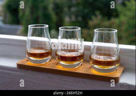 Flug von Single Malt Scotch Whisky, serviert auf einer alten Fensterbank im Scottisch House mit Blick auf den alten Teil der Stadt Edinburgh, Schottland, Großbritannien, mit einem Schluck Whisky Stockfoto