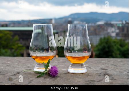 Zwei Gläser Single Malt Scotch Whisky und Blick vom Calton Hill auf den Park und die Altstadt von Edinburgh an regnerischen Sommertagen, Schottland, Großbritannien Stockfoto