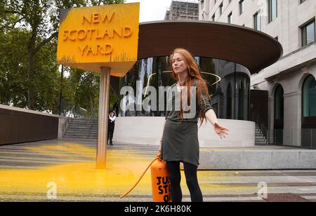 Ein „Just Stop Oil“-Spray malt ein Schild vor dem New Scotland Yard in London. Bilddatum: Freitag, 14. Oktober 2022. Stockfoto