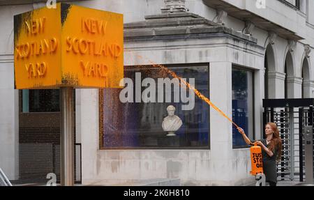 Ein „Just Stop Oil“-Spray malt ein Schild vor dem New Scotland Yard in London. Bilddatum: Freitag, 14. Oktober 2022. Stockfoto